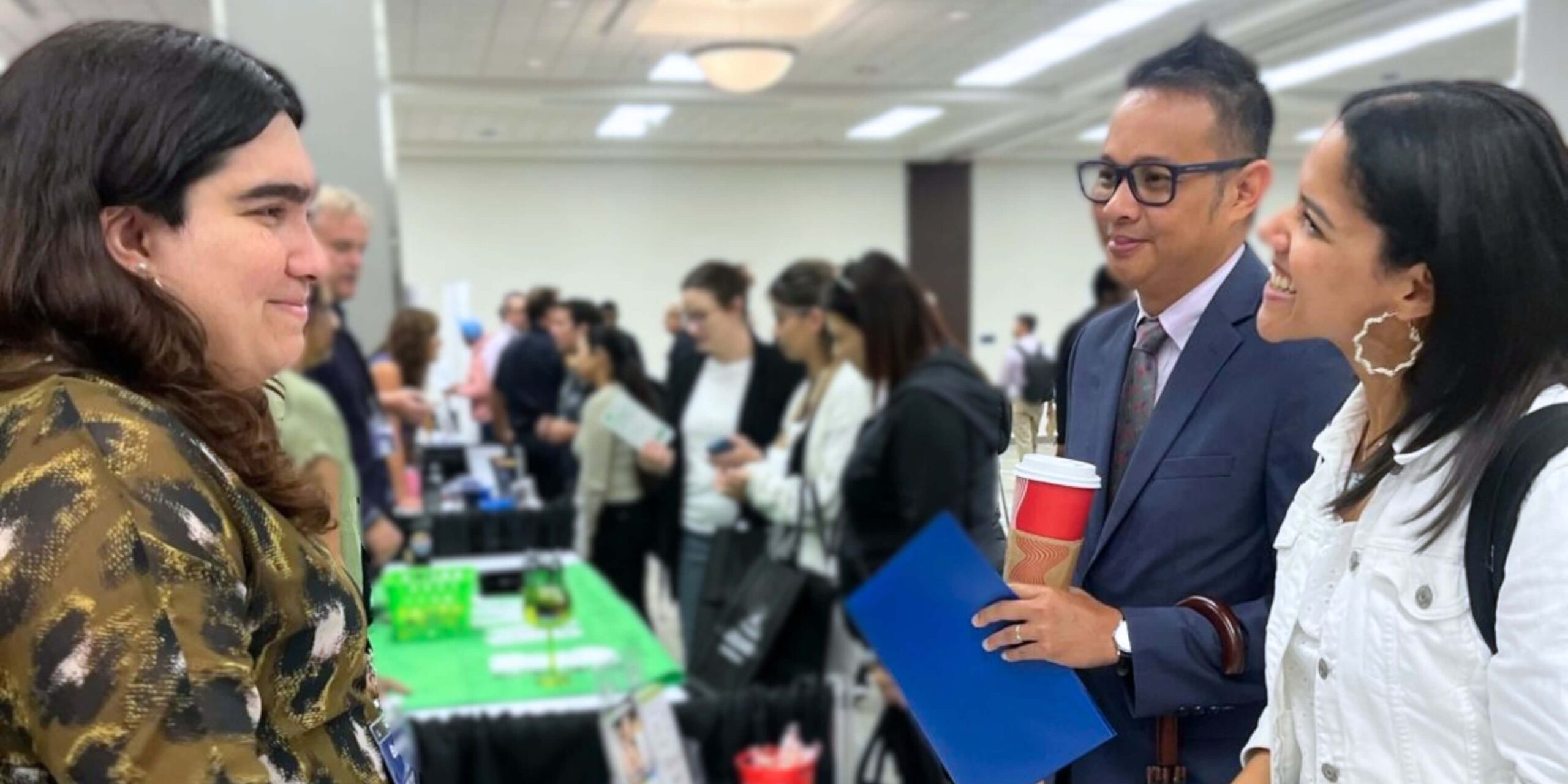 Career fair attendees discussing job opportunities with recruiters